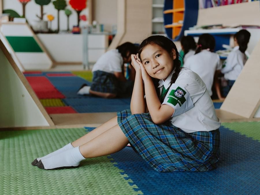 Student in school uniform sitting in a Thai classroom