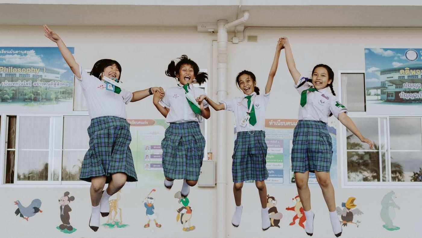 Thai students in school uniform jumping for joy